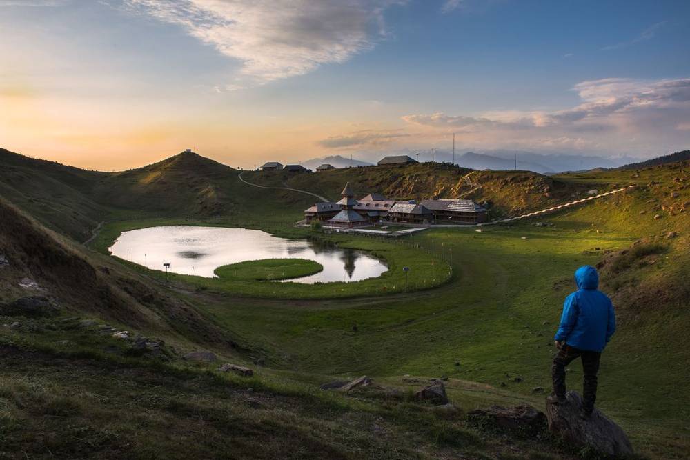 Parashar Lake with its round floating island in a green meadow at sunset